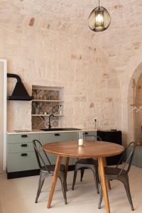 a kitchen with a wooden table and chairs at Aqua Suite - Stone Spa - A Few Minutes from Polignano, Monopoli & Alberobello in Castellana Grotte
