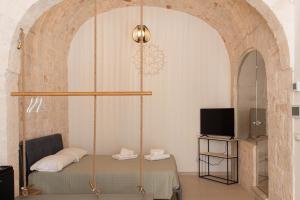 a room with a bed and a swing at Aqua Suite - Stone Spa - A Few Minutes from Polignano, Monopoli & Alberobello in Castellana Grotte