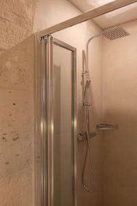 a shower with a glass door in a bathroom at Aqua Suite - Stone Spa - A Few Minutes from Polignano, Monopoli & Alberobello in Castellana Grotte