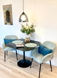 a black table with two chairs and a vase of flowers at Alpen Liebe Prem in Prem +22 photos