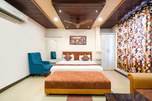 a bedroom with two beds and a blue chair at FabHotel Prakash & Sons, Hoshangabad Rd in Somarda Kauasot +33 photos