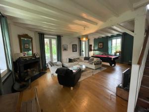 a living room with couches and a pool table at Au moulin d'Izaourt in Izaourt