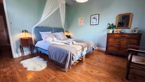 a bedroom with a bed with a blue headboard and a mirror at Au moulin d'Izaourt in Izaourt