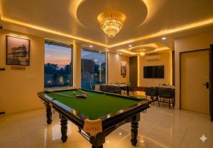 a pool table in a living room with a chandelier at Hotel The Hidden Door-Near Jaipur Airport in Jaipur