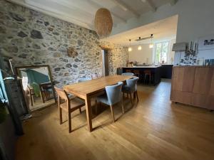 a kitchen and dining room with a wooden table and chairs at Au moulin d'Izaourt in Izaourt