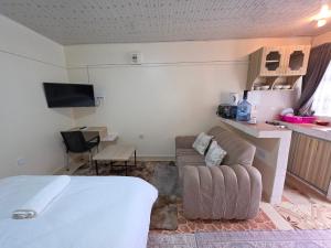 a living room with a bed and a couch at Rosemond cottages eldoret in Eldoret