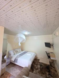 a bedroom with a large bed and a table at Rosemond cottages eldoret in Eldoret