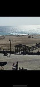 a group of people on a beach near the ocean at Apartamento Lances playa tarifa in Tarifa