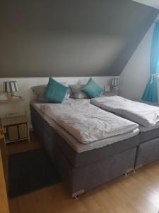 a bedroom with two twin beds with blue pillows at Schlei-Liesels Ferienwohnungen in Güby