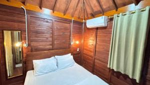 a small room with a bed and a shower at Sandyakala Borobudur in Magelang