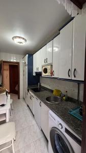 a kitchen with a sink and a washing machine at piso en la playa in Noja
