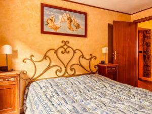 a bedroom with a bed and a painting on the wall at Casa al Sasso - Appartamenti immersi nella natura in Lizzano in Belvedere