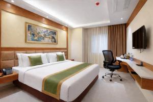 a hotel room with a bed and a desk at Hotel Green View in Baharampur