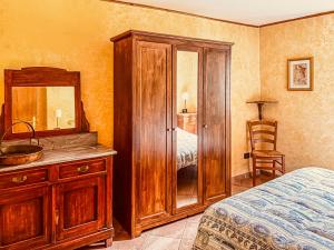 a bedroom with a wooden cabinet and a mirror at Casa al Sasso - Appartamenti immersi nella natura in Lizzano in Belvedere