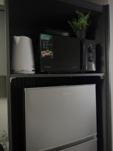 a microwave oven sitting on top of a refrigerator at AD PRESTIGE Apartment in Gradačac +13 photos