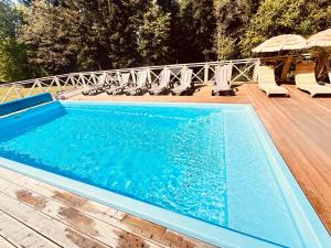 a large swimming pool with chairs and a deck at Chałupy w Lesie Skawinki in Skawinki +40 photos