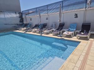 a row of chairs and a swimming pool at Vila Paun in Costinesti