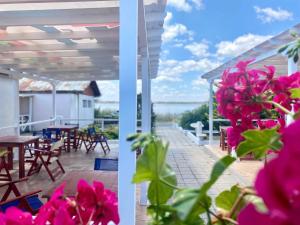 two views of a patio with tables and pink flowers at Бунгала в Поморие in Pomorie