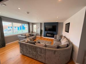 a living room with a large couch and a flat screen tv at 6 Pegasus Place in Lerwick