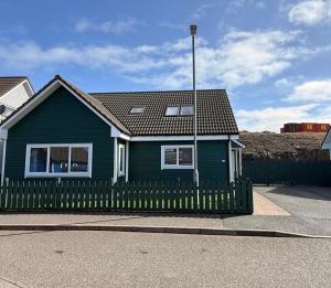 a blue house with a fence in front of it at 6 Pegasus Place in Lerwick