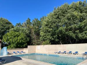 a swimming pool with lounge chairs and a wall at La maison papillons in Quissac +11 photos