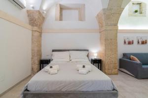 a bedroom with a large bed and a couch at Atena Ortigia in Syracuse