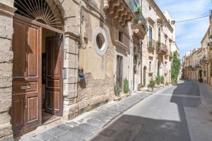 an alley in an old town with an open door at Atena Ortigia in Syracuse