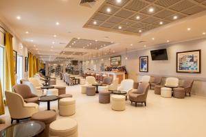 a waiting room with chairs and tables and a salon at Vila Gale Albacora in Tavira