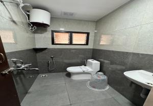 a bathroom with a toilet and a sink at Nandha Grande Elite in Udumalaippettai