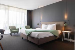 a hotel room with a bed and a large window at Van der Valk Hotel Sassenheim - Leiden in Sassenheim +111 photos