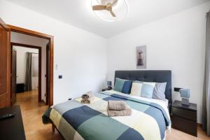 a bedroom with a large bed with blue and white sheets at Casa Andrada in Yaiza +27 photos