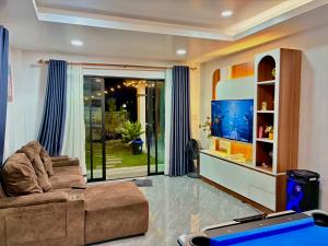 a living room with a couch and a flat screen tv at Bonus Pool Villa Chiang Mai in Chiang Mai