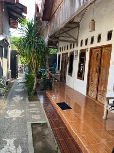 a porch of a house with a wooden floor at Coral Choice in Gili Trawangan +17 photos