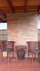 two tables and two chairs in front of a wall at Sandyakala Borobudur in Magelang