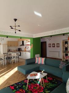 a living room with a blue couch and a kitchen at Casa Măriucăi - Ciubar&Mountain View in Borşa