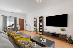 a living room with a couch and a flat screen tv at Casa Andrada in Yaiza