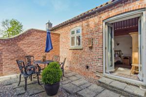 a patio with chairs and a table with an umbrella at 1 Bed in Market Rasen oc-73852 in East Barkwith