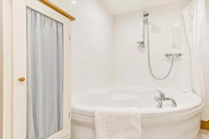 a white bathroom with a tub and a sink at 1 Bed in Market Rasen oc-73852 in East Barkwith +24 photos