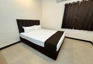 a bedroom with a large bed with a black headboard at Nandha Grande Elite in Udumalaippettai