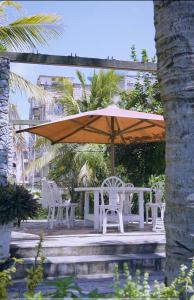 a table and chairs under an umbrella on a patio at TULIVU Homes in Mombasa