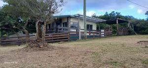 a house with a fence and a tree at Piedra de Luna o Sur in Villa Serrana