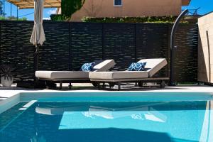 two lounge chairs sitting next to a swimming pool at Villa Aquilla in Tivat