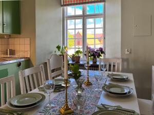 a dining room table with plates and glasses on it at Guest apartment in the castle in Höör +18 photos