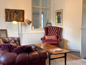 a living room with a leather couch and a coffee table at Guest apartment in the castle in Höör