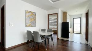 a dining room with white walls and a table and chairs at BenHill - serviced apartment-Binh Duong in Ấp Dừa