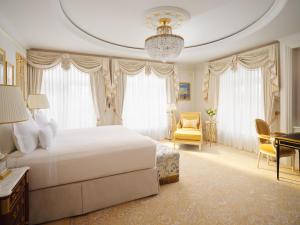 a bedroom with a large white bed and a desk at The Ritz London in London +46 photos