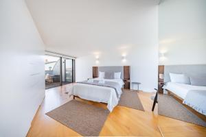 a bedroom with two beds and a mirror at Pedrinhas Village by Geyra in Esposende