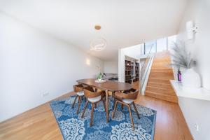 a dining room with a table and chairs on a rug at Pedrinhas Village by Geyra in Esposende