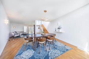 a dining room with a table and chairs on a rug at Pedrinhas Village by Geyra in Esposende