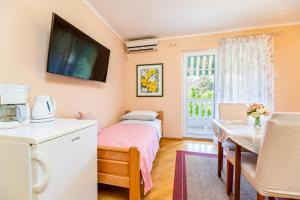a room with a bed and a table and a kitchen at Rooms Nadica in Baška